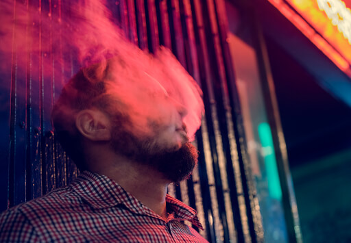 Man exhaling smoke from a hemp cannagar.
